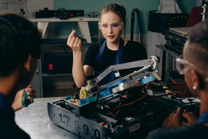 Junge Ingenieurinnen und Ingenieure arbeiten gemeinsam an einem Robotik-Projekt